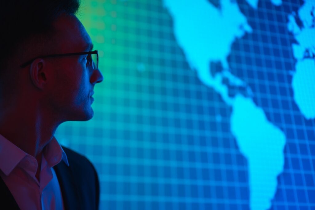 The businessman in glasses looking at map of the US and south america